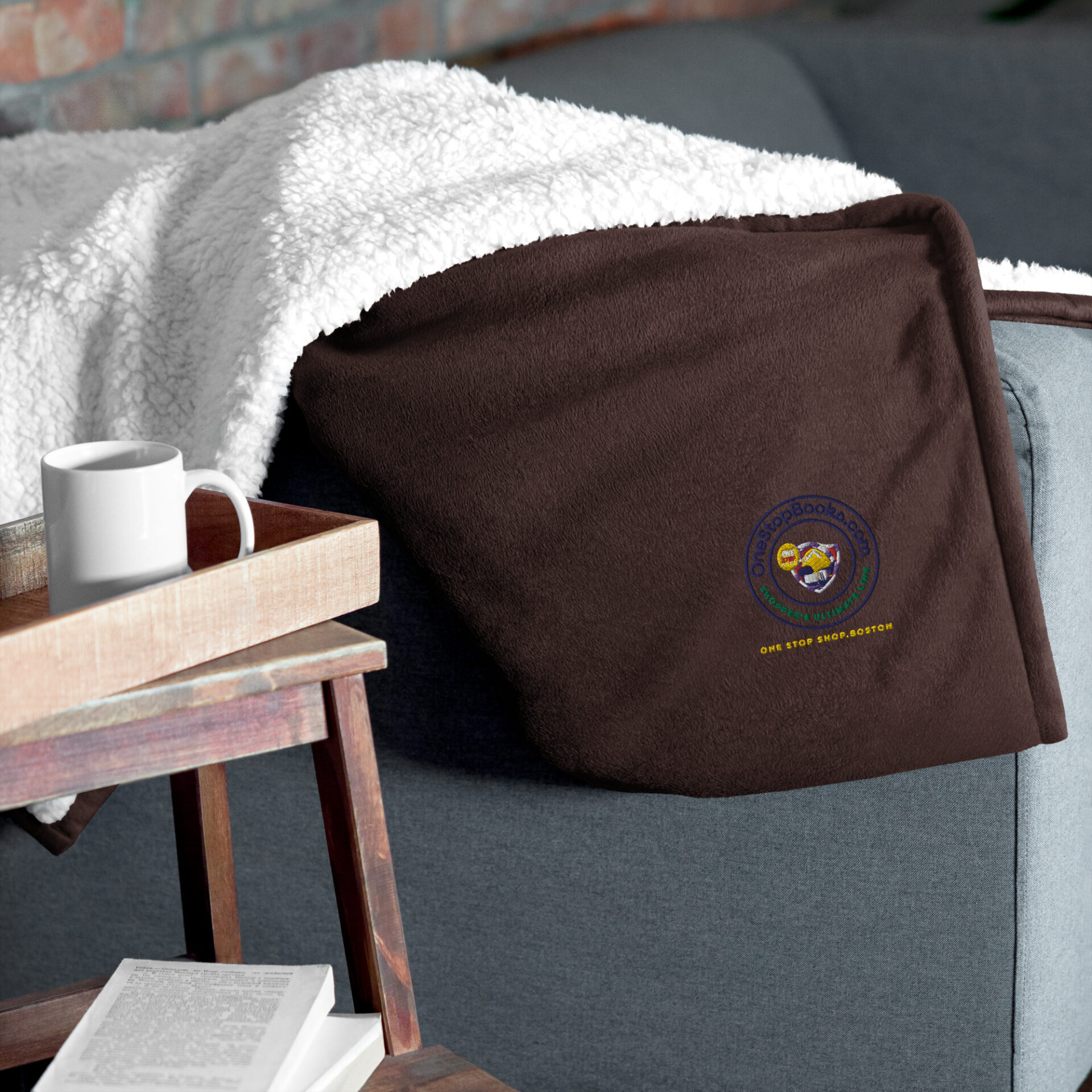 Brown fleece blanket with logo on couch.