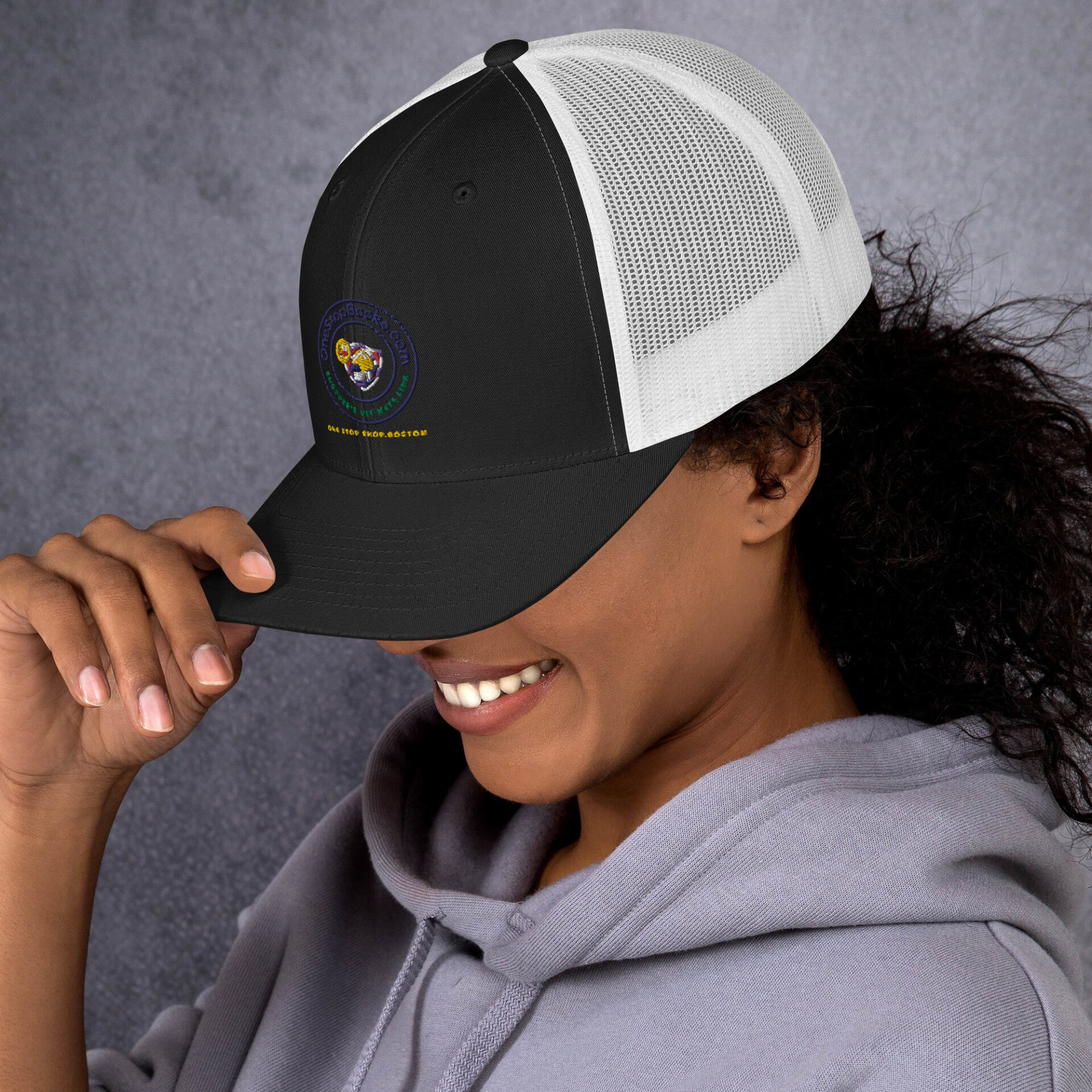 Woman wearing a black and white trucker hat.