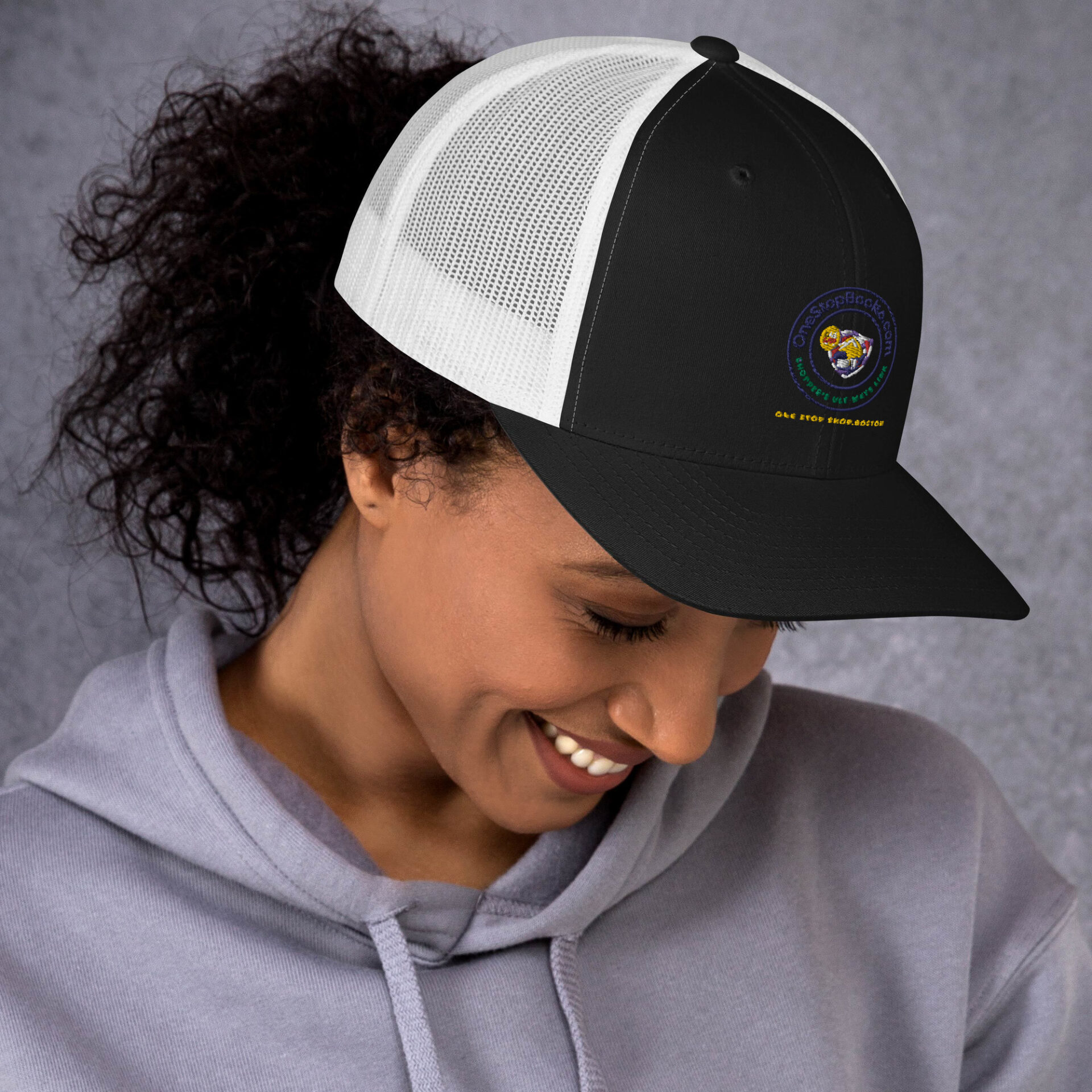 Woman smiling in a black and white hat.