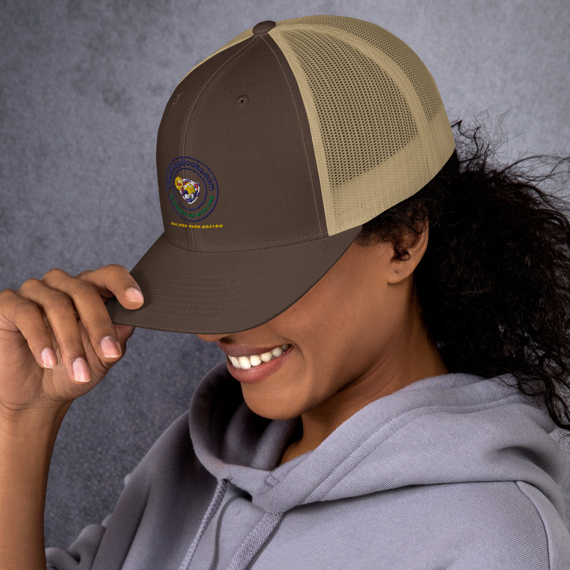 Woman wearing a brown and tan trucker hat.