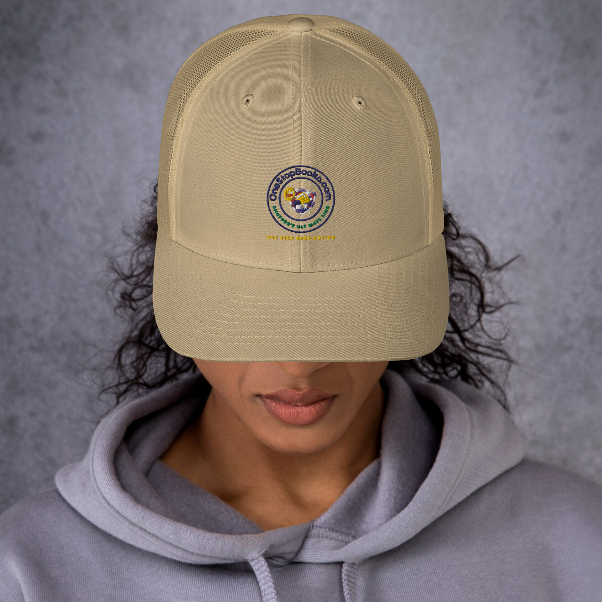 Person wearing a beige baseball cap with logo.