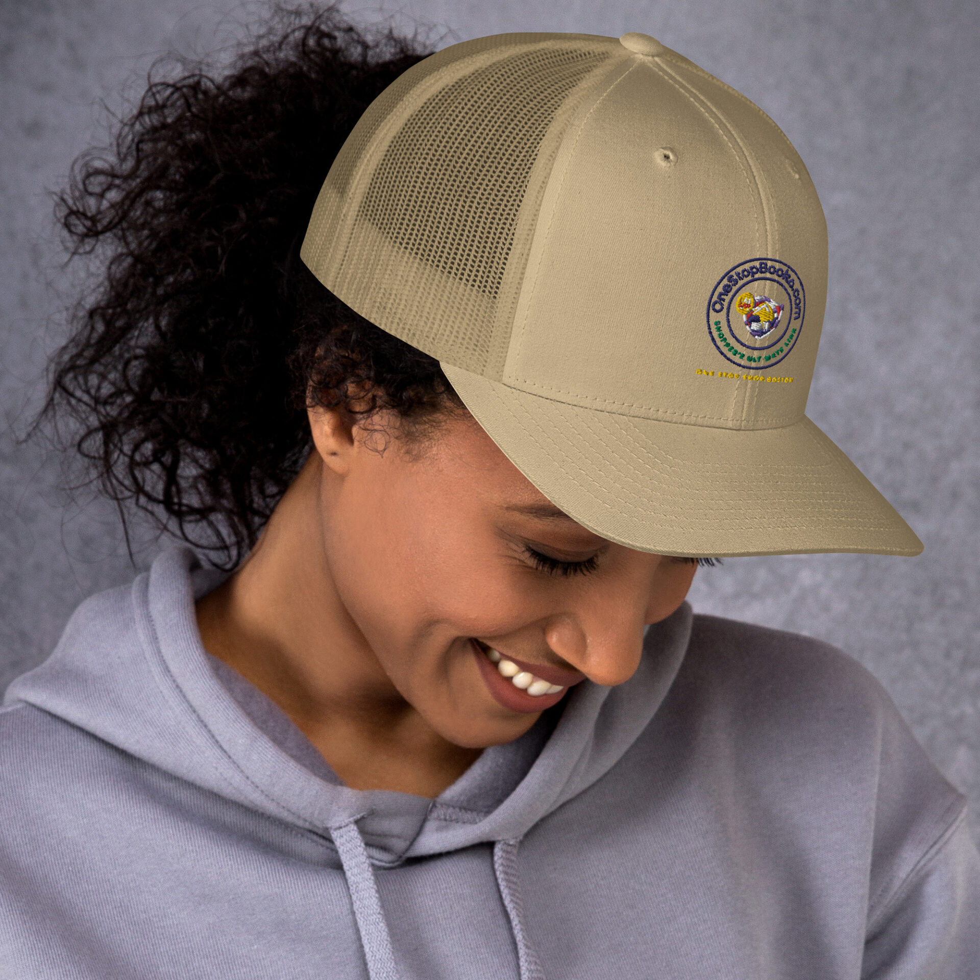 Woman wearing a beige One Stop Books cap.