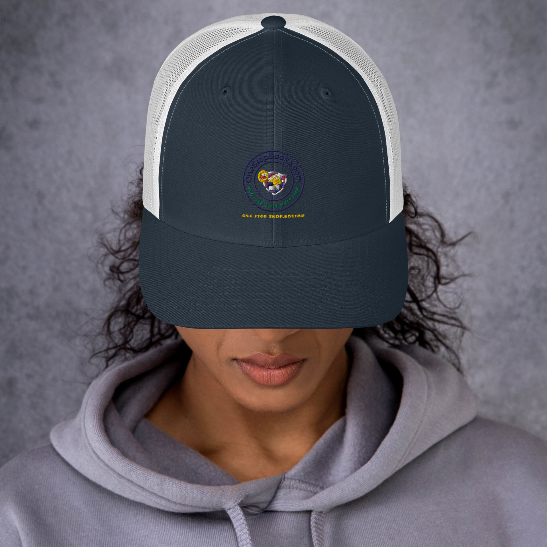 Person wearing a navy blue and white trucker hat.