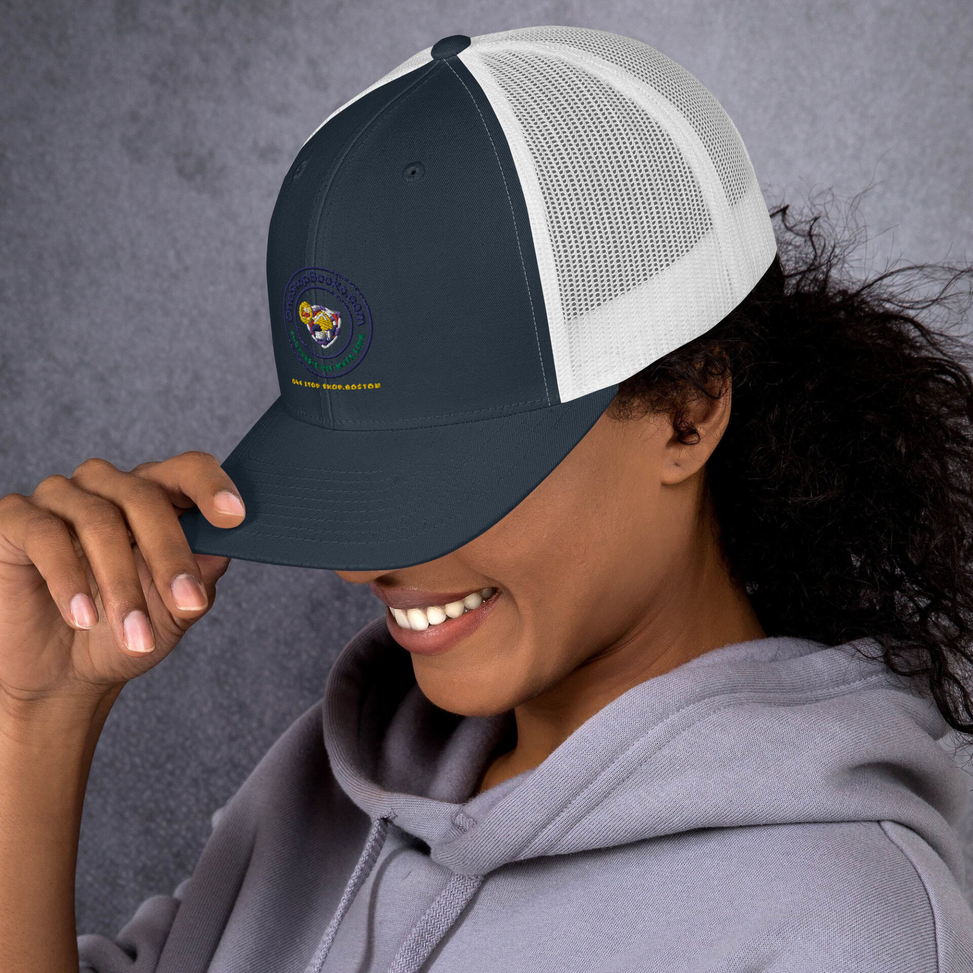 Woman smiling wearing a blue and white hat.