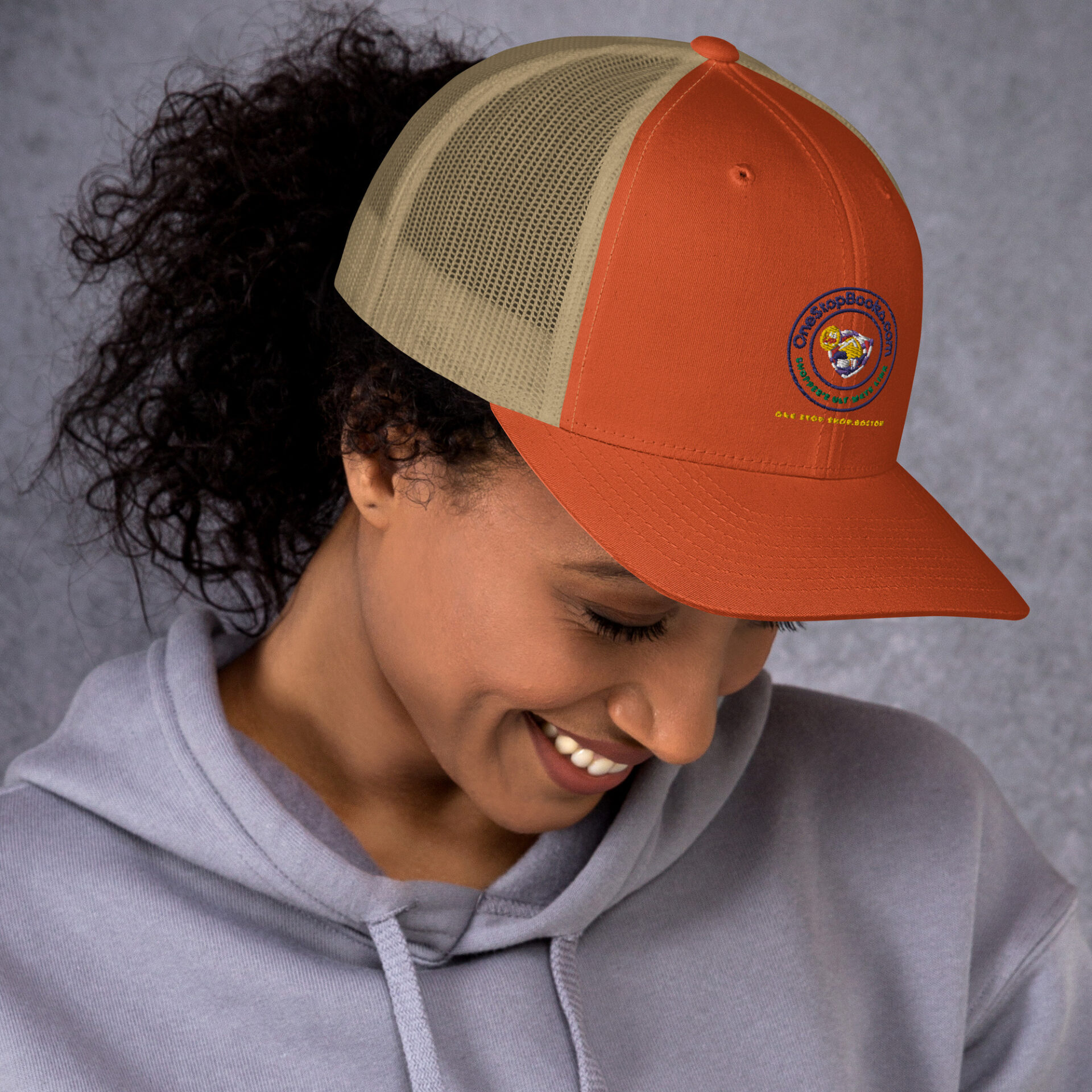 Woman wearing a brown and tan baseball cap.