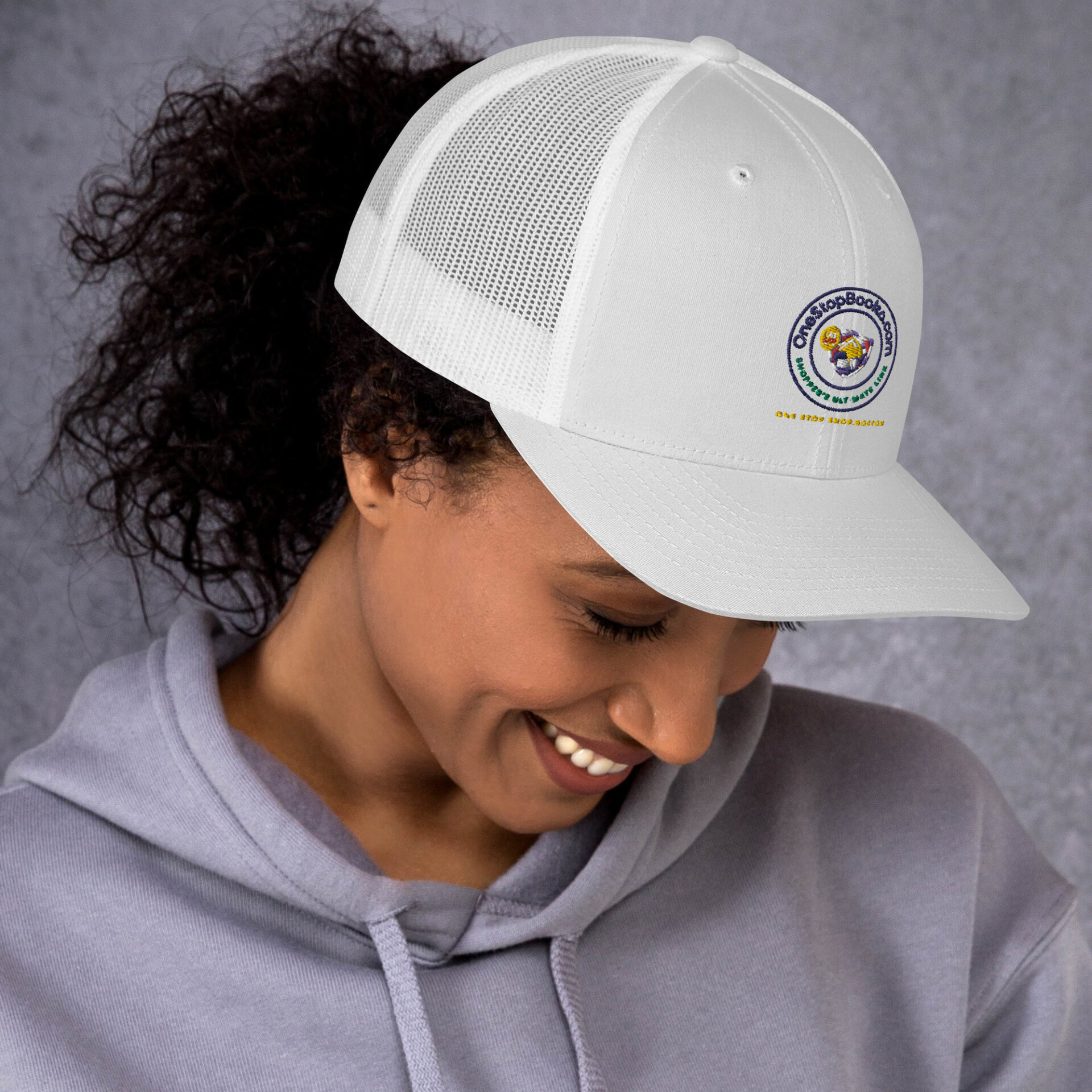 Woman smiling while wearing a white hat.