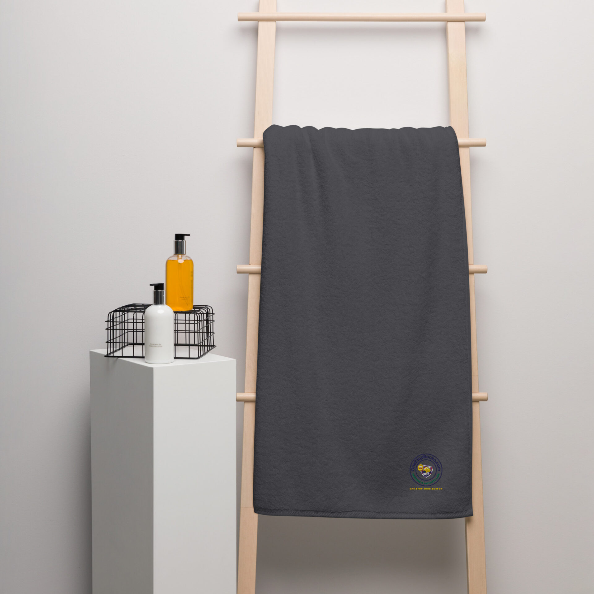 Gray towel on wooden rack with logo.