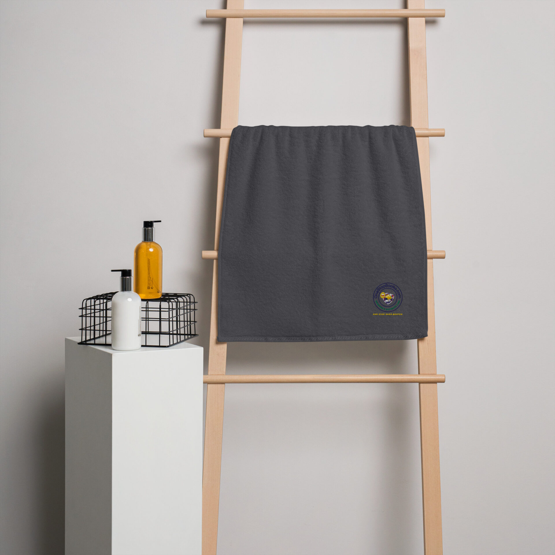 Gray towel with logo on wooden ladder.