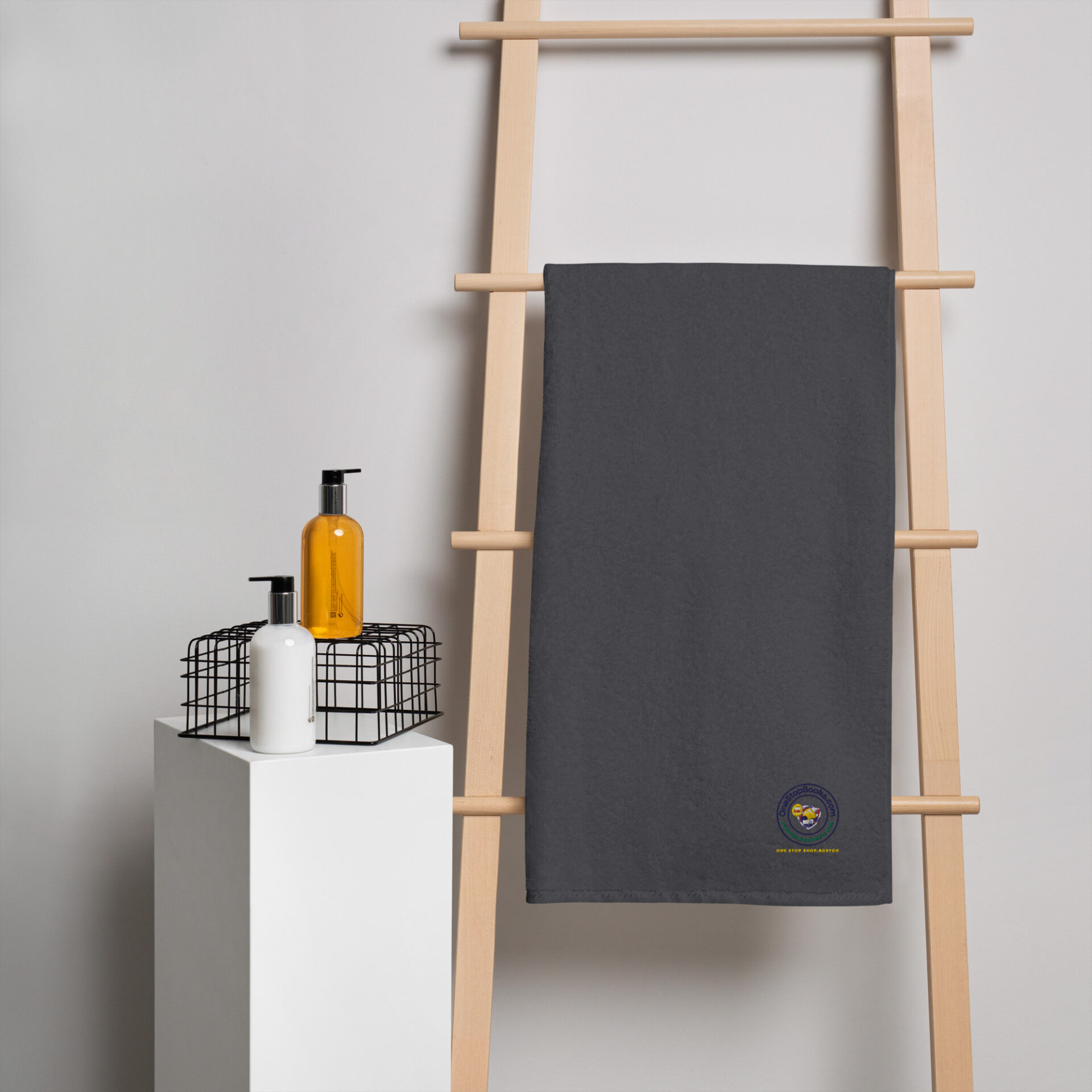 Gray towel hanging on wooden rack with logo.