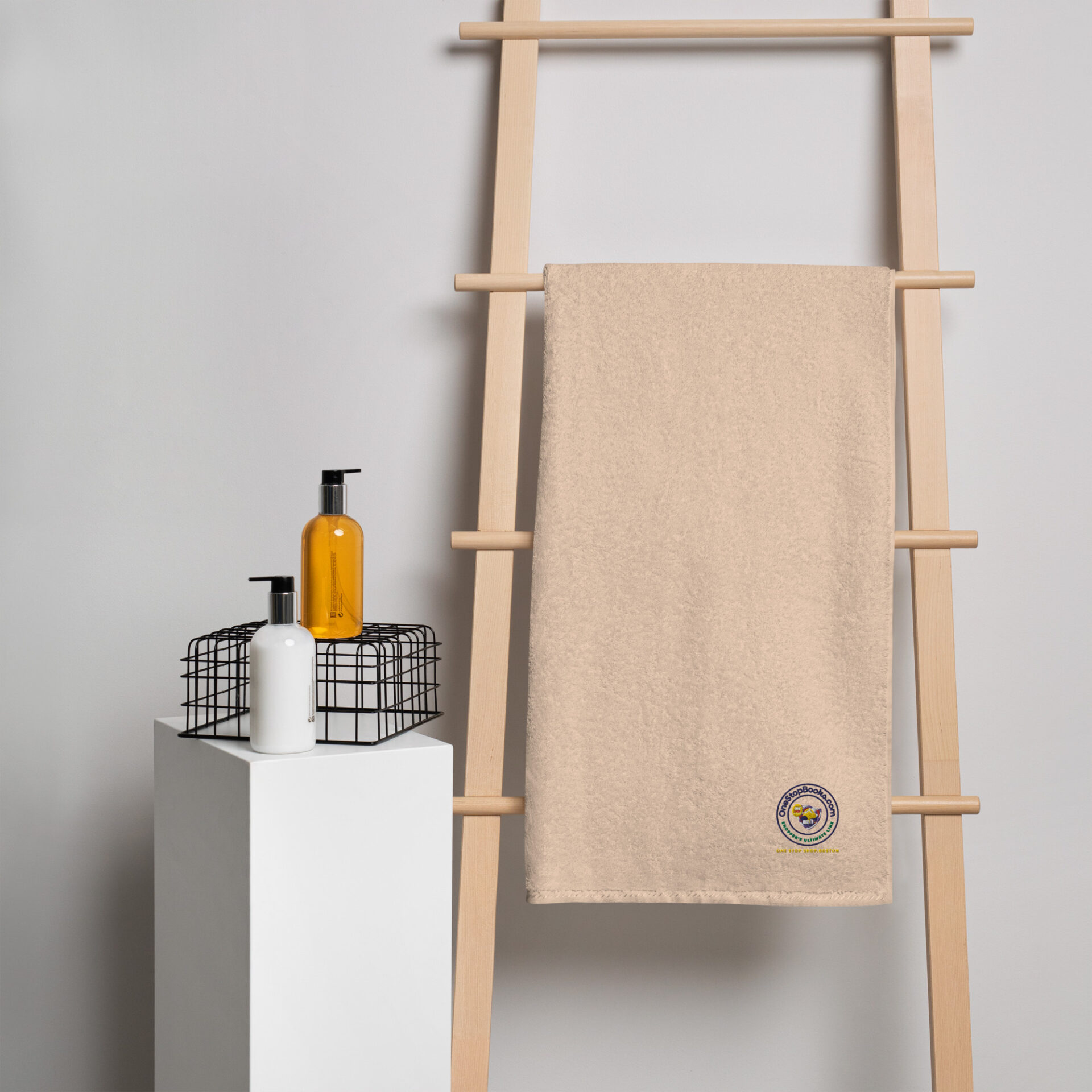 Beige towel on wooden rack with logo.