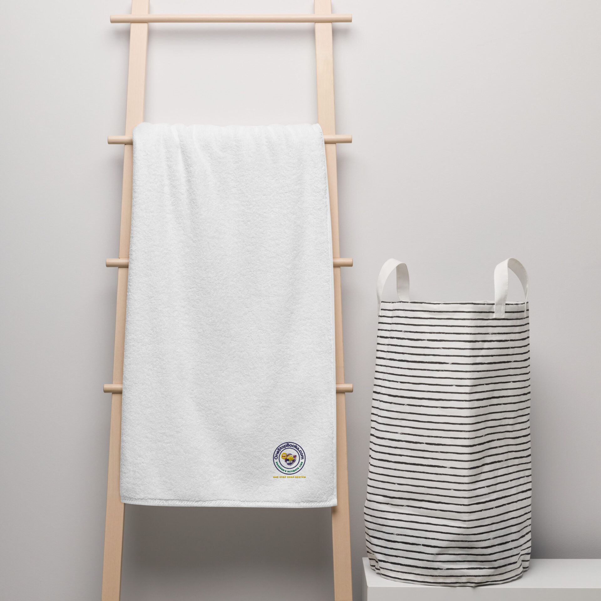 White towel hanging on wooden rack with laundry basket.