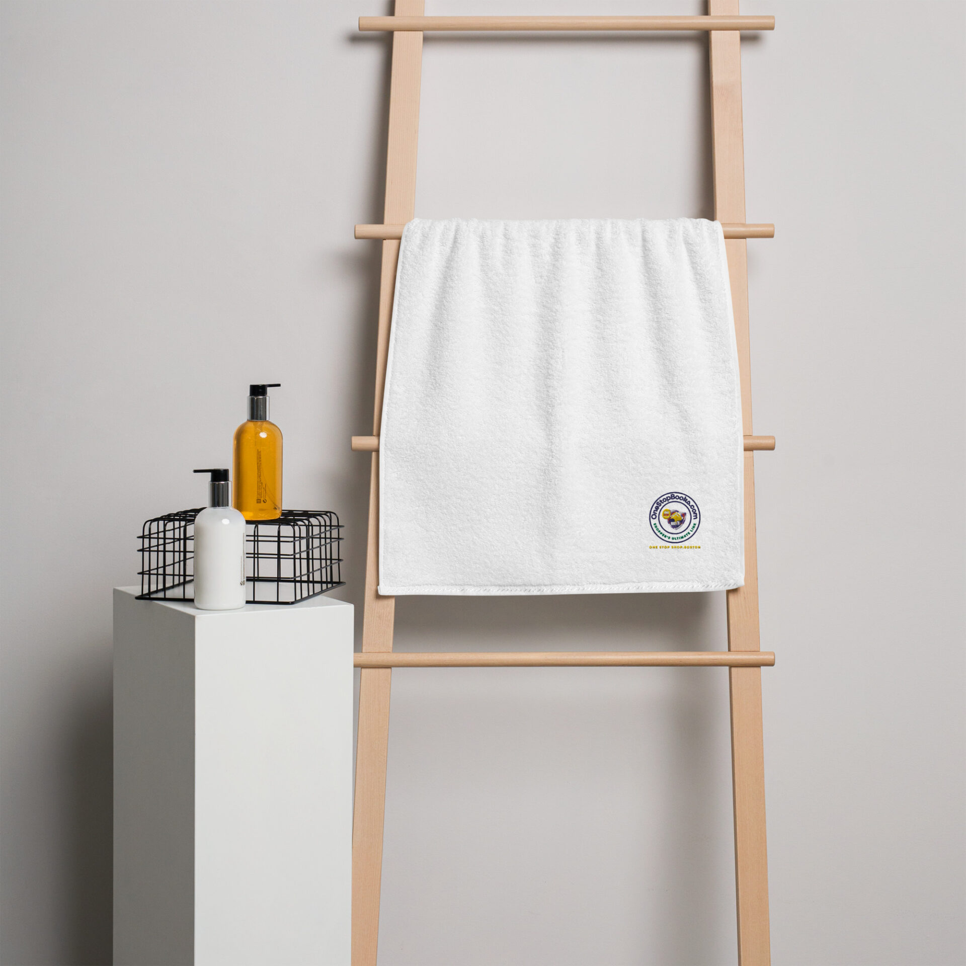 White towel with logo on wooden ladder.