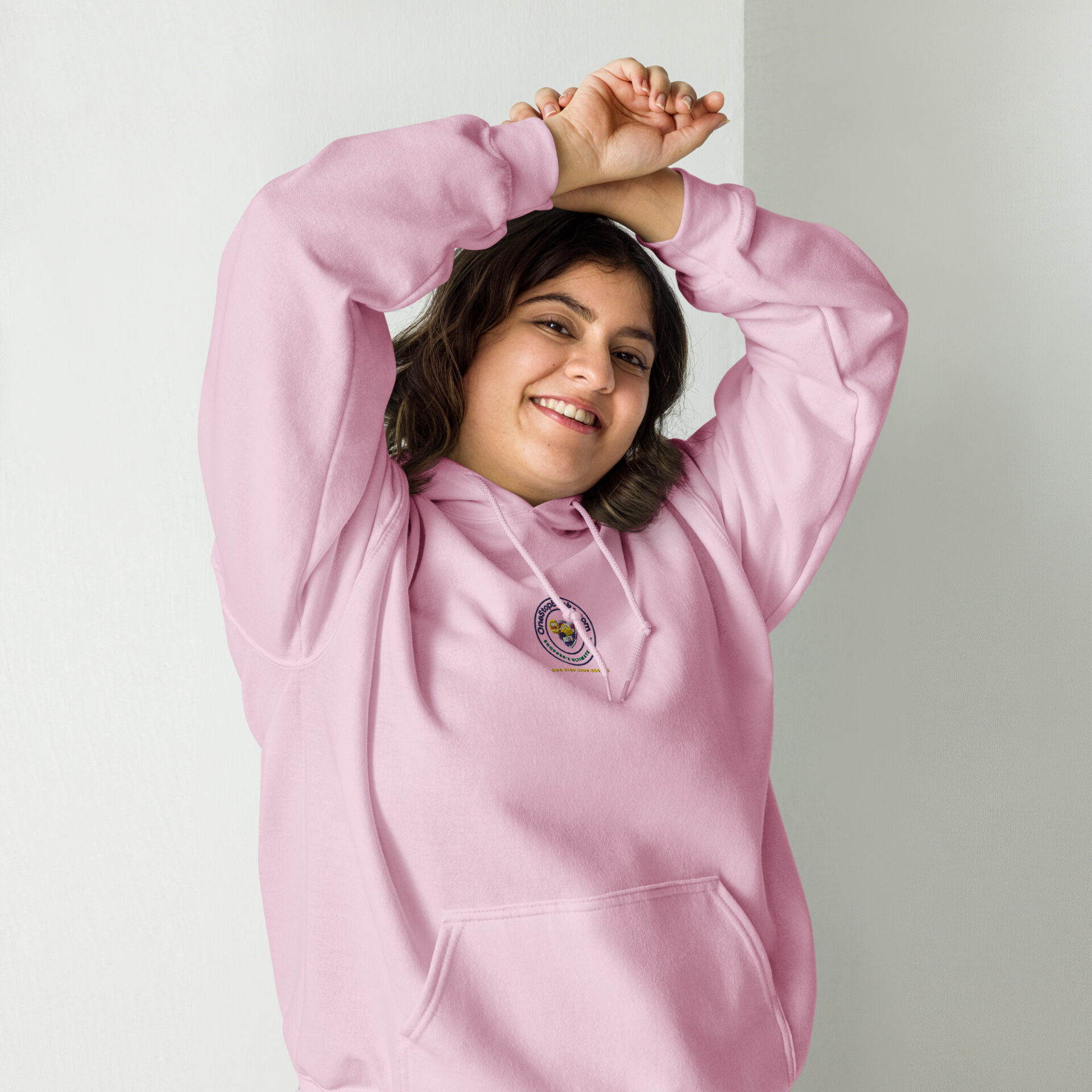 Smiling woman in pink hoodie with logo.
