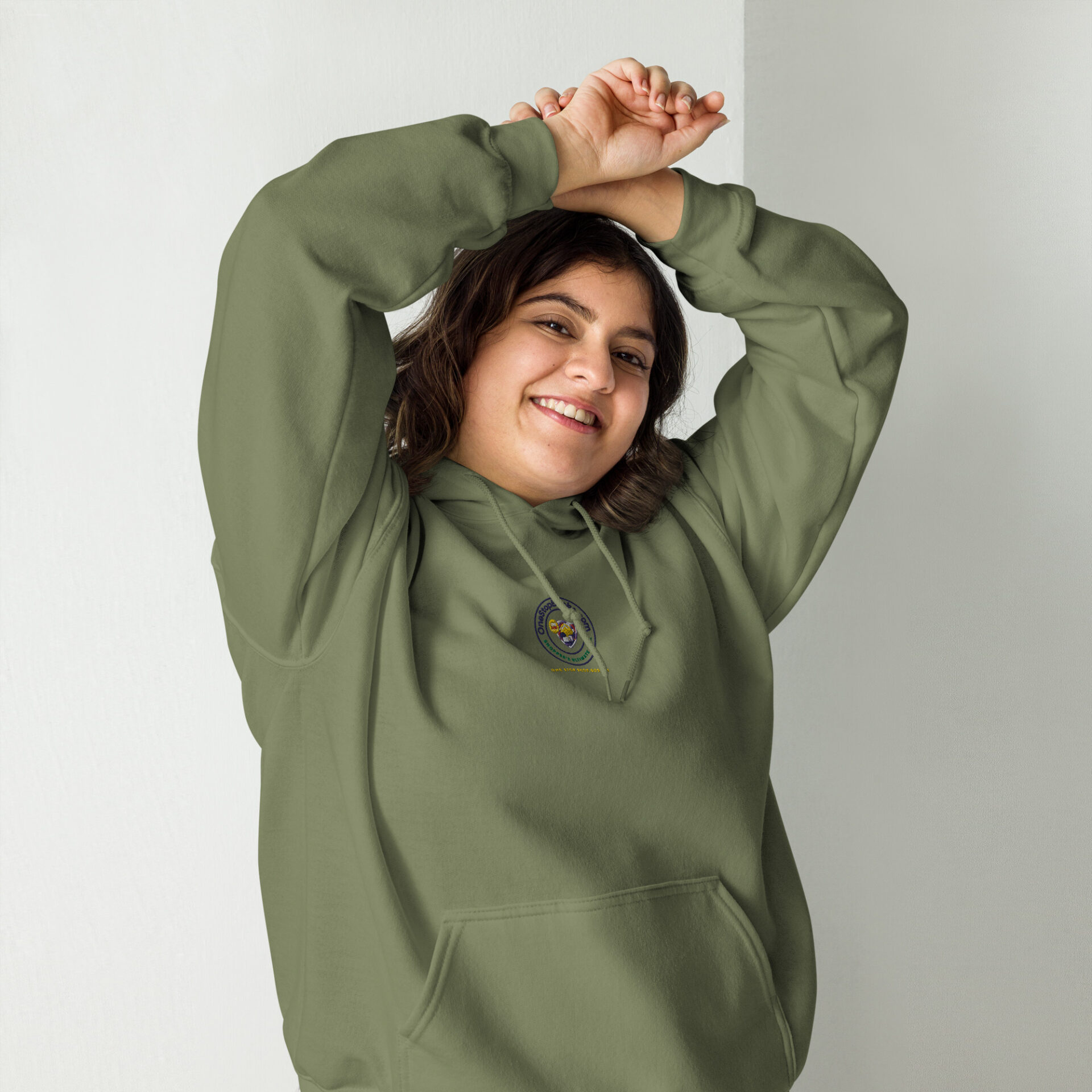 Woman smiling in green hoodie.