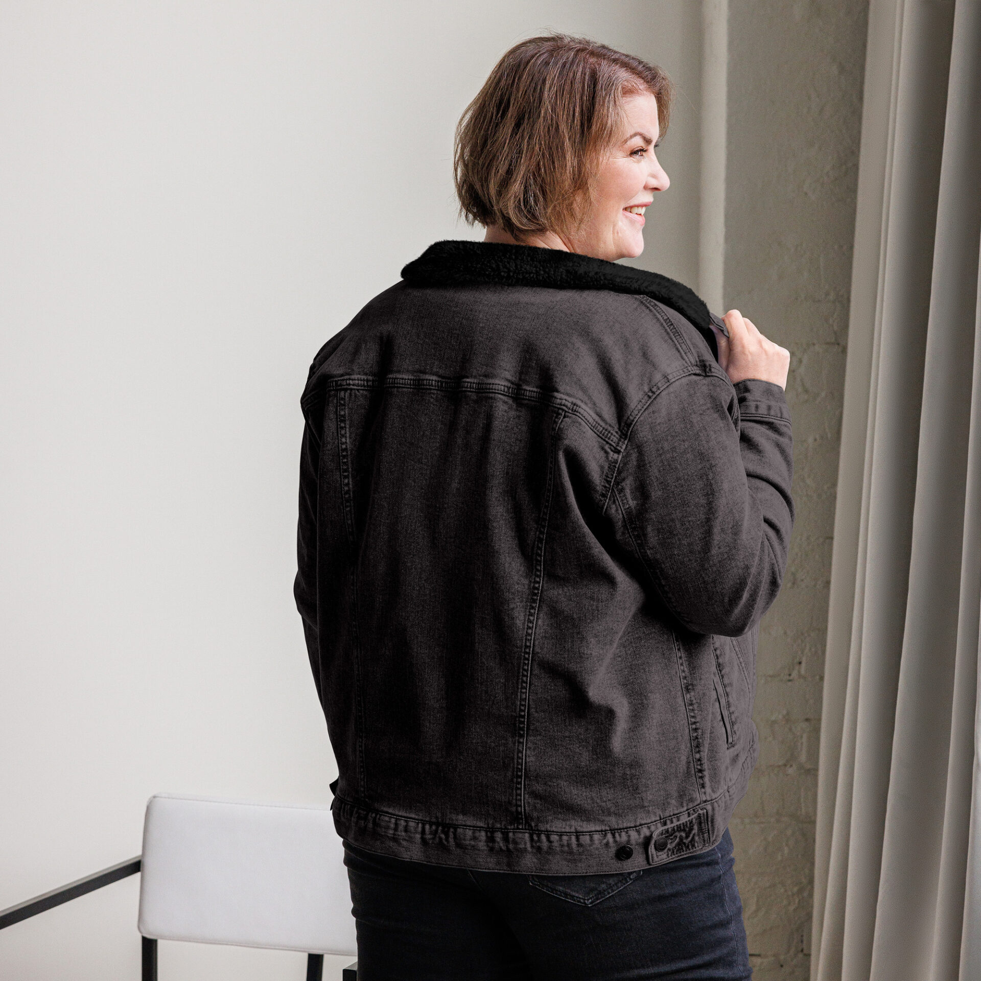 Woman wearing a black denim jacket.
