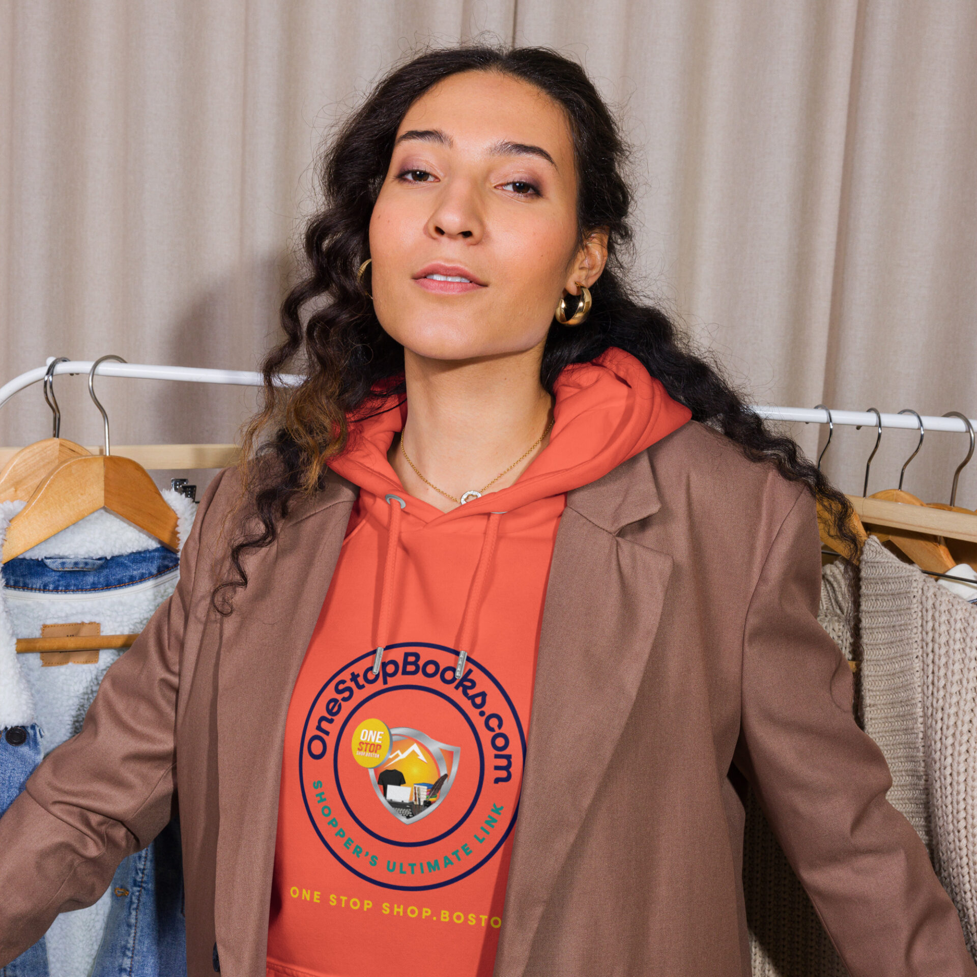 Woman wearing an orange hoodie with logo.